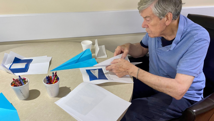 Elderly person making paper airplanes.